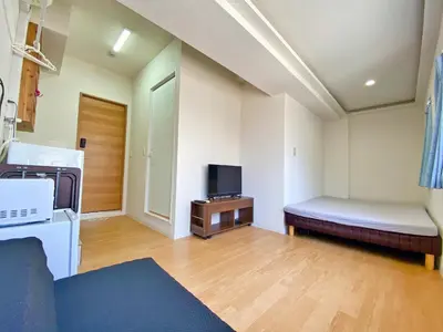 a small room with a bed and a tv at Skytree\u8eca\u7ad9\u5f92\u6b655\u5206 Tokyo\u6771\u4eac\u591c\u666f \u6a5f\u5834\u76f4\u9054 \u5e36\u5eda\u623f \u6d17\u8863\u6a5f \u96fb\u68af4 in Tokyo