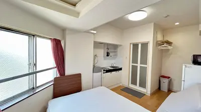 a small room with a bed and a kitchen at Skytree\u8eca\u7ad9\u5f92\u6b655\u5206 Tokyo\u6771\u4eac\u591c\u666f \u6a5f\u5834\u76f4\u9054 \u5e36\u5eda\u623f \u6d17\u8863\u6a5f \u96fb\u68af4 in Tokyo