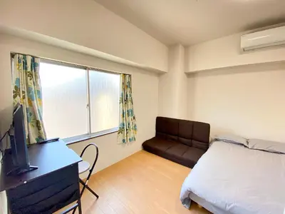 a bedroom with a bed and a couch and a window at Skytree\u8eca\u7ad9\u5f92\u6b655\u5206 Tokyo\u6771\u4eac\u591c\u666f \u6a5f\u5834\u76f4\u9054 \u5e36\u5eda\u623f \u6d17\u8863\u6a5f \u96fb\u68af4 in Tokyo