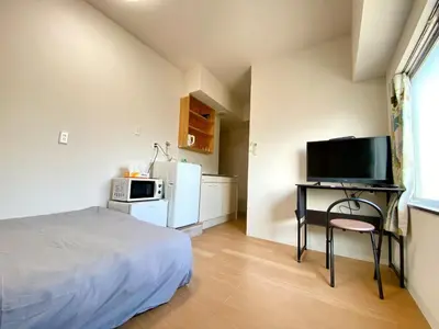 a bedroom with a bed and a desk with a television at Skytree\u8eca\u7ad9\u5f92\u6b655\u5206 Tokyo\u6771\u4eac\u591c\u666f \u6a5f\u5834\u76f4\u9054 \u5e36\u5eda\u623f \u6d17\u8863\u6a5f \u96fb\u68af4 in Tokyo