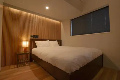 a bedroom with a large bed and a window at Besso Ebisu in Tokyo