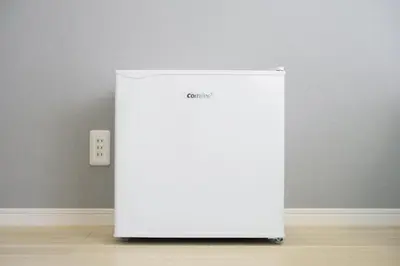 a white refrigerator in a room with a wall at Kohoku Apartment in Tokyo