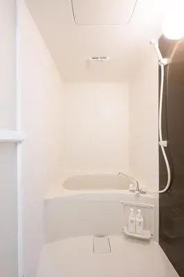 a white bathroom with a shower and a sink at Kohoku Apartment in Tokyo