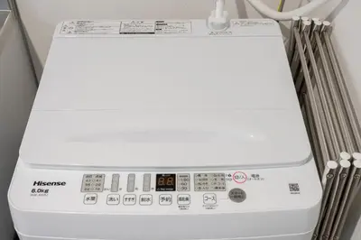 a white washing machine sitting in a room at Alley Tateishi in Tokyo