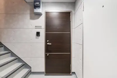 a wooden door in a hallway with stairs at Alley Tateishi in Tokyo