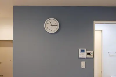 a clock on a wall with a blue wall at Negishi 101-TT0029 in Tokyo
