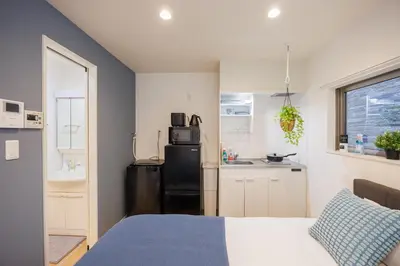 a bedroom with a black refrigerator and a kitchen at Negishi 101-TT0029 in Tokyo