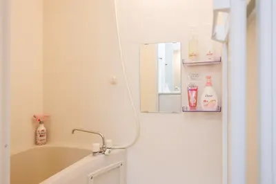 a bathroom with a mirror and a tub and a sink at Negishi 301-TT0030 in Tokyo