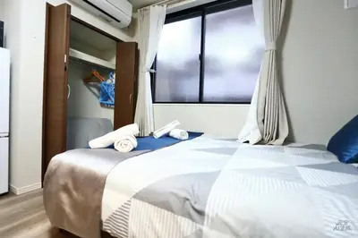 a bedroom with a bed with towels on it at 5 Min to Ikebukuro by Tobu Tojo Line I Oyama Private Suites in Tokyo