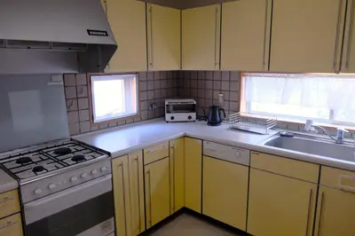 a kitchen with yellow cabinets and a stove and a sink at Shibuya Goten in Tokyo