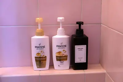 three bottles of cleaning products sitting on a shelf in a bathroom at Shibuya Goten in Tokyo