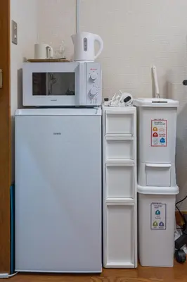 a microwave sitting on top of a refrigerator at Setagaya Quiet Residential Apartment201 in Tokyo