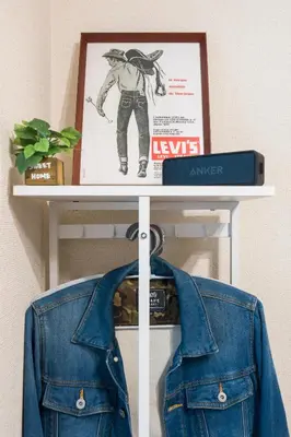 a blue denim jacket on a shelf with a poster at Setagaya Quiet Residential Apartment201 in Tokyo