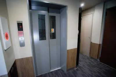 a hallway with two elevators in a building at iruka hotel 15 minutes to Shinjuku and Shibuya in Tokyo