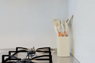 a kitchen counter with two stove tops and a vase with utensils at Diamond Residences in Tokyo