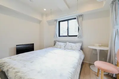 a small bedroom with a bed and a window at Diamond Residences in Tokyo