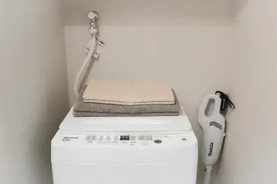 a washing machine with a towel on top of it at Diamond Residences in Tokyo