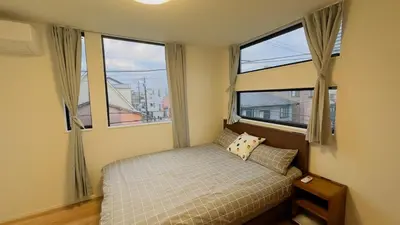 a bedroom with a bed and two large windows at new open \u4e00\u6237\u5efa \u5bb6\u5ead \u591a\u4eba\u5165\u4f4f \u76f4\u8fbe\u4e0a\u91ce\u6d45\u8349 Skytree \u6210\u7530\u7fbd\u7530\u7a7a\u6e2f in Tokyo