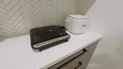 a phone sitting on a table next to a coffee maker at new open \u4e00\u6237\u5efa \u5bb6\u5ead \u591a\u4eba\u5165\u4f4f \u76f4\u8fbe\u4e0a\u91ce\u6d45\u8349 Skytree \u6210\u7530\u7fbd\u7530\u7a7a\u6e2f in Tokyo