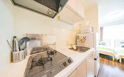 a kitchen with a stove top oven next to a sink at 30 min to Ueno, Asakusa, Skytree, Akihabara, Ginza in Tokyo
