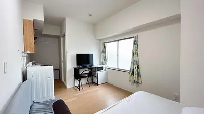 a bedroom with a bed and a desk with a television at Skytree\u8eca\u7ad9\u5f92\u6b655\u5206 Tokyo\u6771\u4eac\u591c\u666f \u6a5f\u5834\u76f4\u9054 \u5e36\u5eda\u623f \u6d17\u8863\u6a5f \u6709\u96fb\u68af4 in Tokyo