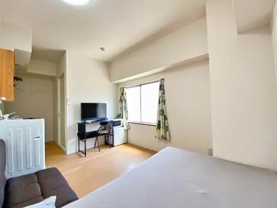 a bedroom with a couch and a desk and a window at Skytree\u8eca\u7ad9\u5f92\u6b655\u5206 Tokyo\u6771\u4eac\u591c\u666f \u6a5f\u5834\u76f4\u9054 \u5e36\u5eda\u623f \u6d17\u8863\u6a5f \u6709\u96fb\u68af4 in Tokyo