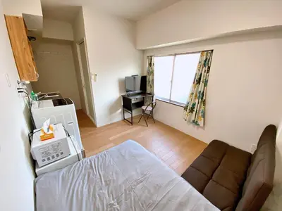 a room with a bed and a couch and a television at Skytree\u8eca\u7ad9\u5f92\u6b655\u5206 Tokyo\u6771\u4eac\u591c\u666f \u6a5f\u5834\u76f4\u9054 \u5e36\u5eda\u623f \u6d17\u8863\u6a5f \u6709\u96fb\u68af4 in Tokyo