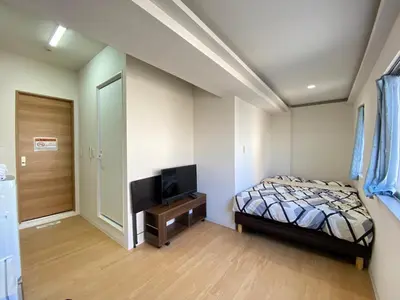 a bedroom with a bed and a flat screen tv at Skytree\u8eca\u7ad9\u5f92\u6b655\u5206 Tokyo\u6771\u4eac\u591c\u666f \u6a5f\u5834\u76f4\u9054 \u5e36\u5eda\u623f \u6d17\u8863\u6a5f \u6709\u96fb\u68af4 in Tokyo