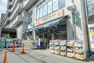 a store front of a grocery store with orange cones in front at unito residence WASEDA West in Tokyo