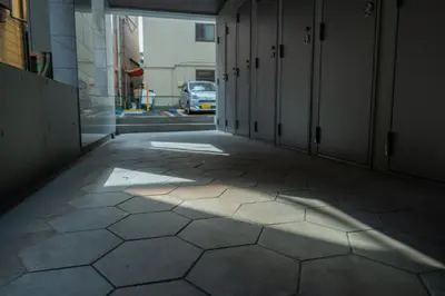 a hallway of a building with a shadow on the floor at unito residence WASEDA West in Tokyo