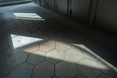 an empty hallway with sunlight shining on a tiled floor at unito residence WASEDA West in Tokyo