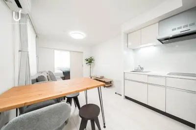 a kitchen and dining room with a wooden table and chairs at unito residence WASEDA West in Tokyo