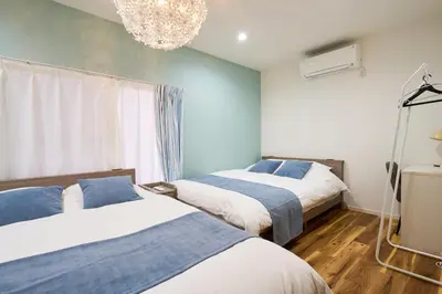 a bedroom with two beds and a chandelier at YAHIRO Base, 6m walk Yahiro Sta 94m2 2LDK Villa,3 Baths in Tokyo
