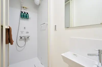 a white bathroom with a shower and a sink at YAHIRO Base, 6m walk Yahiro Sta 94m2 2LDK Villa,3 Baths in Tokyo