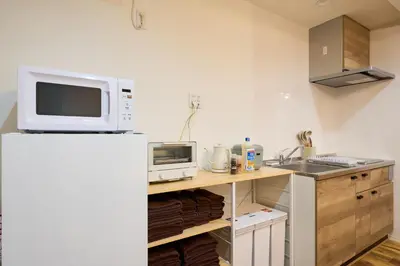 a kitchen with a microwave and a refrigerator at YAHIRO Base, 6m walk Yahiro Sta 94m2 2LDK Villa,3 Baths in Tokyo