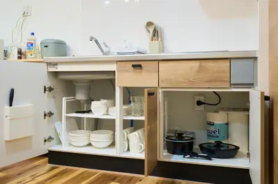 a kitchen cabinet filled with dishes and a sink at YAHIRO Base, 6m walk Yahiro Sta 94m2 2LDK Villa,3 Baths in Tokyo