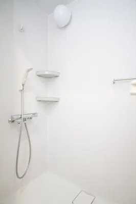 a white bathroom with a shower with a shower head at \u685c\u82b1\u4e0a\u6c34 in Tokyo