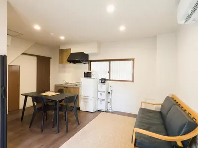 a kitchen and a living room with a table and a couch at \u685c\u82b1\u4e0a\u6c34 in Tokyo