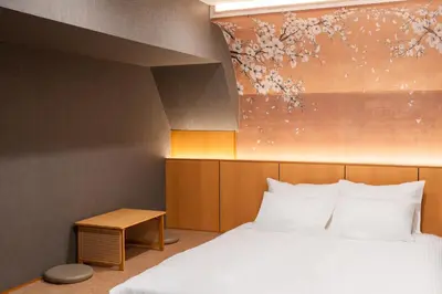 a bedroom with a bed and a painting on the wall at MARUMI HOTEL Asakusa\u6d45\u8349 in Tokyo