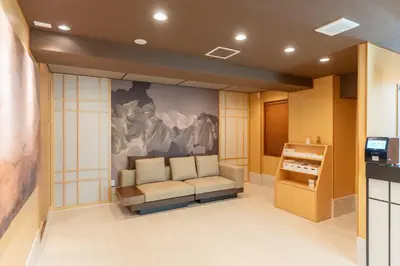 a waiting room with a couch and a painting on the wall at MARUMI HOTEL Asakusa\u6d45\u8349 in Tokyo