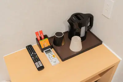 a table with a coffee maker and a remote control at MARUMI HOTEL Asakusa\u6d45\u8349 in Tokyo