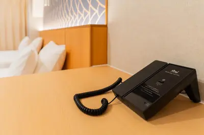 a black phone sitting on a table in a hotel room at MARUMI HOTEL Asakusa\u6d45\u8349 in Tokyo