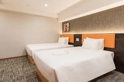 two beds in a hotel room with white sheets at MARUMI HOTEL Asakusa\u6d45\u8349 in Tokyo