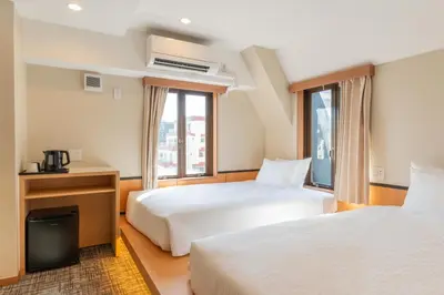 a hotel room with two beds and a window at MARUMI HOTEL Asakusa\u6d45\u8349 in Tokyo