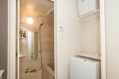 a small bathroom with a washer and dryer at MIHOTEL Nakano- Shinjuku Direct in Tokyo