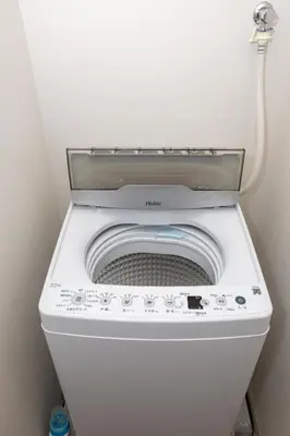 a washing machine with its door open in a bathroom at MIHOTEL Nakano- Shinjuku Direct in Tokyo