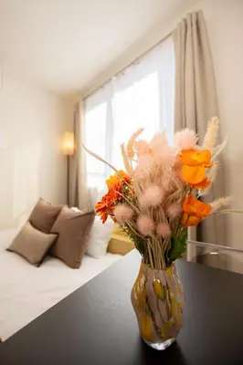 a vase filled with flowers sitting on a table at MIHOTEL Nakano- Shinjuku Direct in Tokyo
