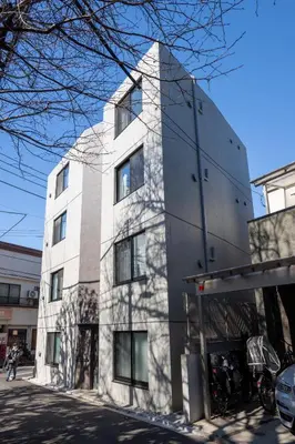 a tall white building on the side of a street at MIHOTEL Nakano- Shinjuku Direct in Tokyo