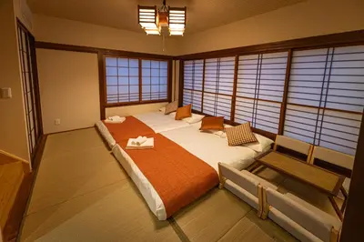 a bedroom with a large bed in a room with windows at KOKORO INN TOKYO 5-minute walk to Senso-ji Temple Four-story private house with two bathrooms luxury stay in Tokyo