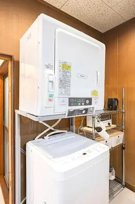 a kitchen with a large white appliance on top of a refrigerator at Soresta INN \u7be0\u5d0e in Tokyo